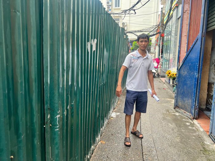 Anh Đinh Trường, người dân ngách 37/2 Lê Thanh Nghị đang trình bày những ảnh hưởng lún, nứt của các hộ liền kề do thi công dự án. Ảnh: PV