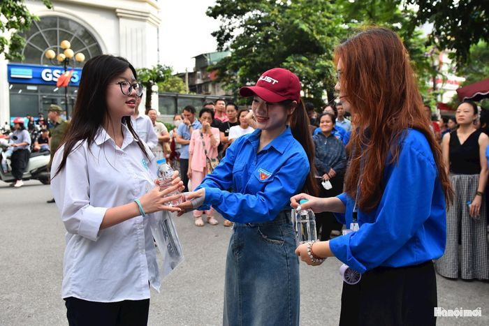 Lực lượng thanh niên tình nguyện tiếp sức cho các thí sinh bằng những chai nước và lời chúc các em hoàn thành tốt bài thi.