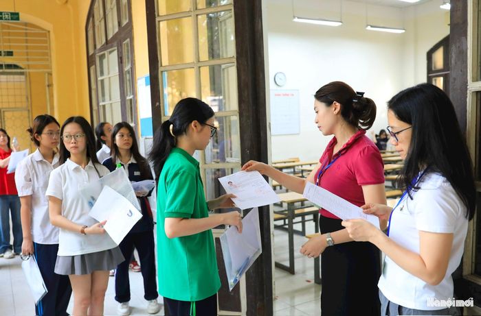 Cán bộ coi thi gọi thí sinh vào phòng thi, kiểm tra thẻ dự thi của thí sinh. Theo quy định, thí sinh được gọi vào phòng thi lúc 7h15. Đến 7h55, cán bộ coi thi sẽ phát đề thi môn ngữ văn.
