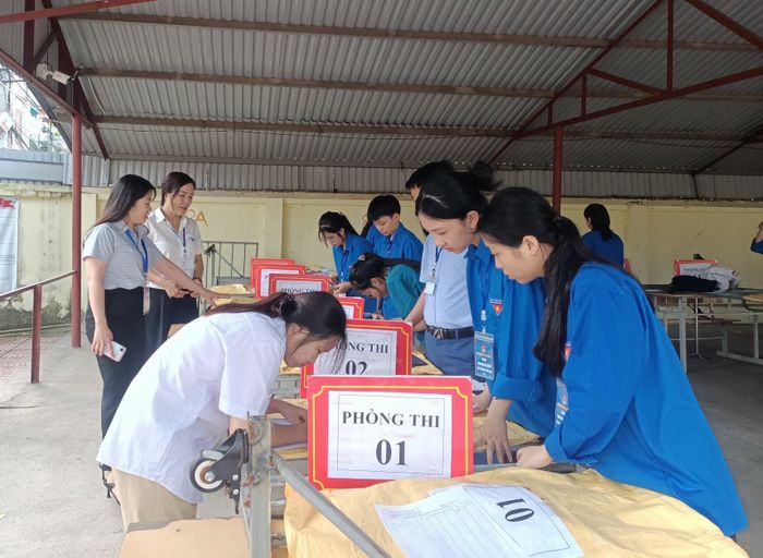 Đoàn thanh niên xã Trung Giã hỗ trợ thí sinh gửi đồ dùng trước khi vào phòng thi. Ảnh: Lê Hằng