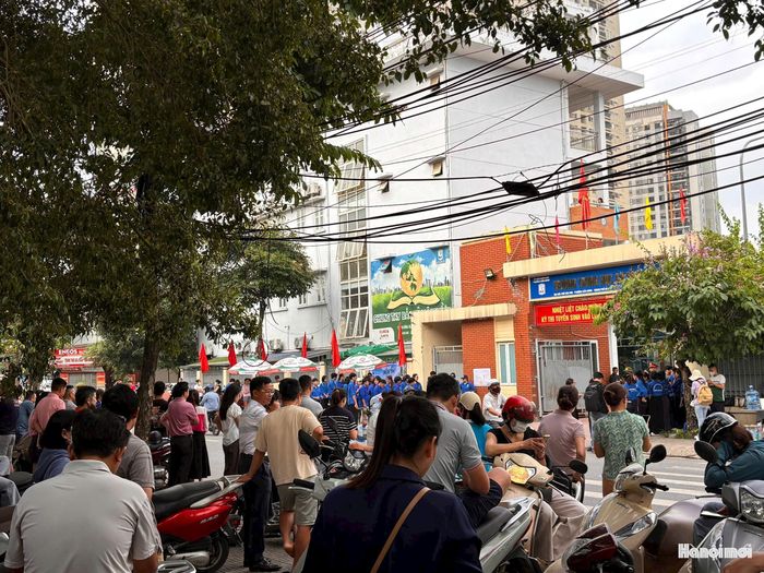 Phụ huynh đau đáu dõi theo con từ cổng trường thi. Ảnh: NM