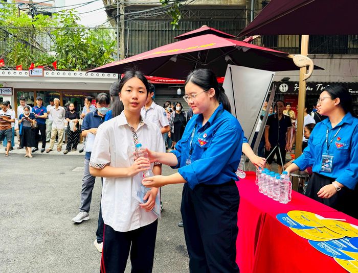 Các thí sinh được phát nước uống đóng chai từ đội thanh niên tình nguyện có mặt tại điểm thi. Ảnh: PV