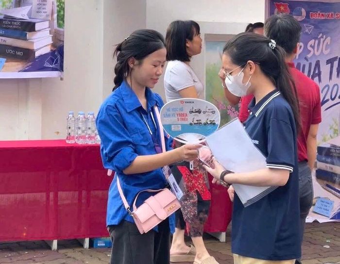 Đoàn viên xã Sóc Sơn tặng nước uống cho các sĩ tử. Ảnh: Tùng Nguyễn.