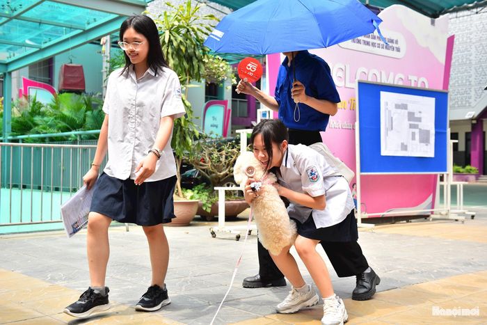 Một thí sinh vui mừng bên chú cún cưng sau khi hoàn thành tốt bài thi.