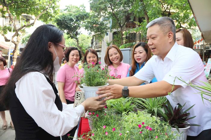 Chủ tịch Công đoàn phường Hoàn Kiếm Đinh Sỹ Đạt đổi cây lấy rác tái chế tại lễ ra mắt. Ảnh: PV