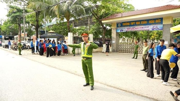 Lực lượng công an xã phân luồng giao thông tại các điểm thi. Ảnh: CT