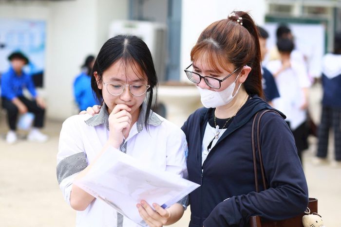 Hồng Ngọc cùng mẹ của mình xem lại đề thi em đã làm:MK