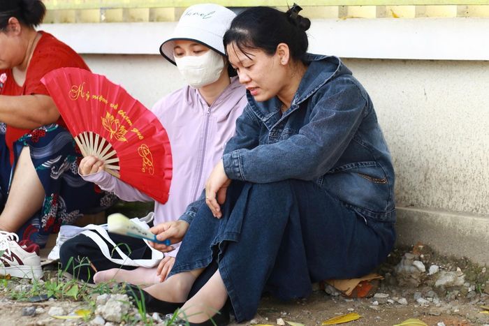 Chị Liên cùng các phụ huynh khác chờ đợi con hoàn thành bài thì của mình. Ảnh:MK