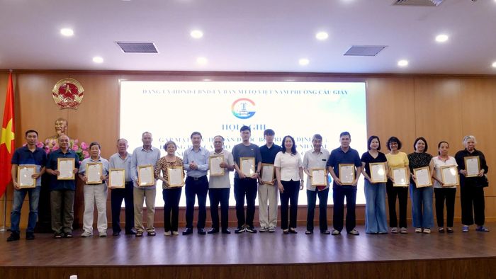Bí thư Đảng ủy, Chủ tịch HĐND phường Cầu Giấy Nguyễn Thị Liễu và Chủ tịch UBND phường Ngô Ngọc Phương trao thư cám ơn cho các hộ gia đình đã đồng thuận, tự nguyện bàn giao mặt bằng. Ảnh: Công Sơn