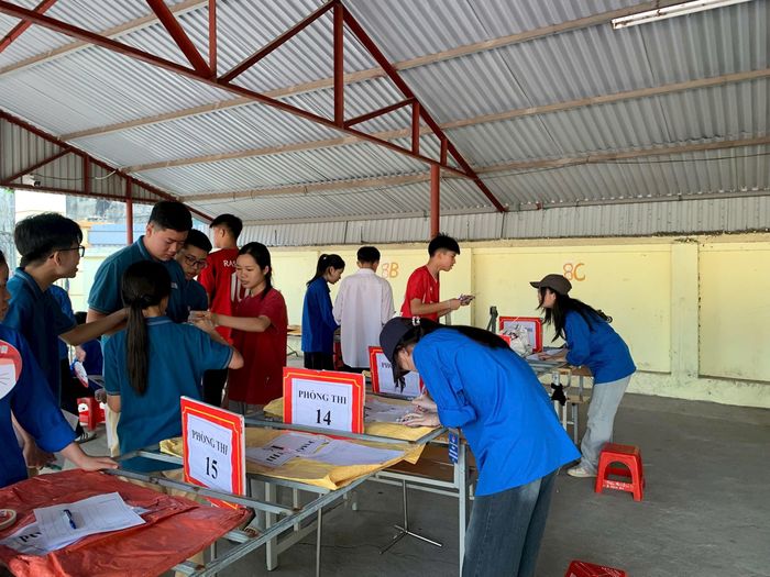 Lực lượng thanh niên hỗ trợ bảo quản tư trang cho thí sinh trước khi vào phòng thi. Ảnh: Hoàng Tâm
