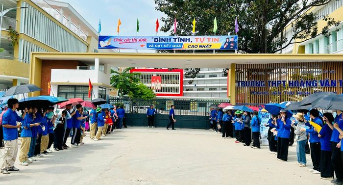 Các đoàn viên túc trực tại cổng Trường THPT Hoàng Văn Thụ chờ thí sinh hoàn thành môn thi ngữ văn. Ảnh: Trần Oanh.