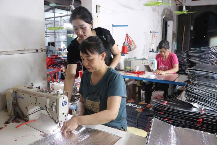 Chị Đinh Thị Hiền hướng dẫn các chị em phụ nữ trong thôn làm quen với công việc. Ảnh: KT