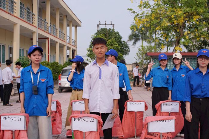 Các đoàn viên hỗ trợ trông giữ đồ cho thí sinh trước khi vào phòng thi. Ảnh: HN