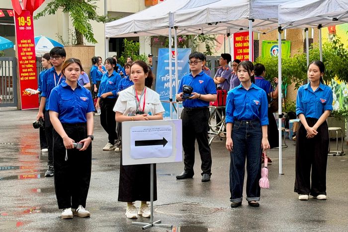 Phó Trưởng phòng Văn hóa - Xã hội phường Ô Chợ Dừa Nguyễn Thu Phương (giữa) cùng lực lượng đoàn viên, thanh niên tình nguyện phối hợp triển khai các hoạt động hỗ trợ thí sinh tại điểm thi. Ảnh: Võ Giang