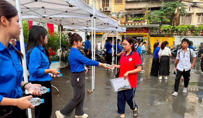 Lực lượng đoàn viên phát nước uống miễn phí, động viên thí sinh. Ảnh: Võ Giang