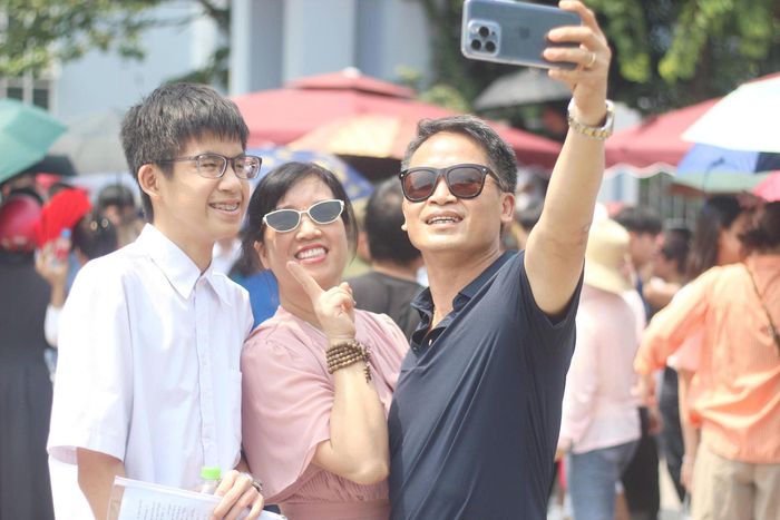  Đón con trước cổng trường, bố mẹ của Khôi cũng không giấu được niềm vui. Ngay sau khi gặp con, cả gia đình đã cùng nhau chụp những bức ảnh kỷ niệm để ghi lại khoảnh khắc khép lại kỳ thi tuyển sinh vào lớp 10. Ảnh: VT 