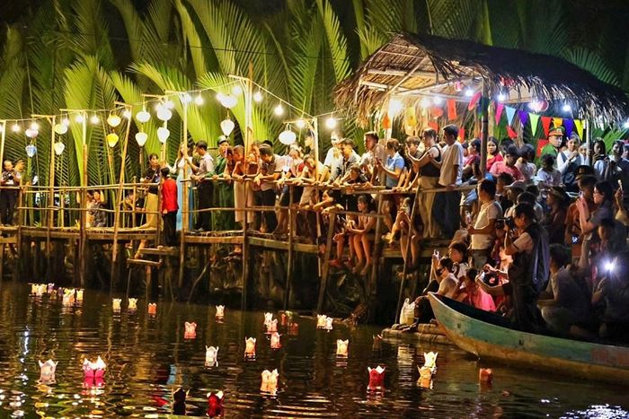 Du khách thích thú ghi lại những khoảnh khắc đẹp bên dòng hoa đăng giữa rừng dừa nước Tịnh Khê