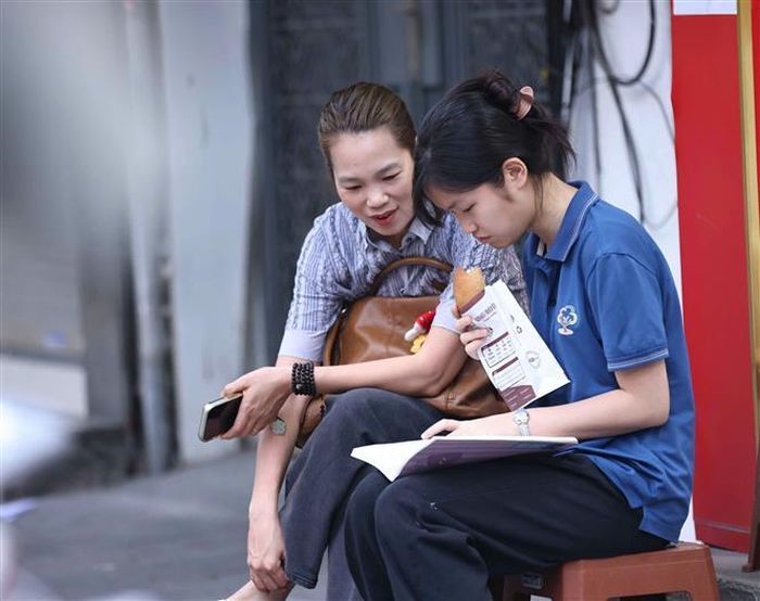 Luôn bên cạnh con trước mỗi môn thi là nguồn động lực tinh thần to lớn giúp các sĩ tử vững bước làm bài, tự tin “vượt vũ môn”. Ảnh: Thanh Tùng - TTXVN