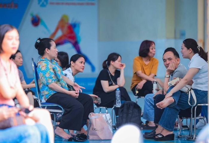 Dù mưa to hay nắng gắt, các bậc phụ huynh vẫn kiên trì chờ đợi thí sinh thi bên ngoài điểm thi. Ảnh: Hoàng Hiếu - TTXVN