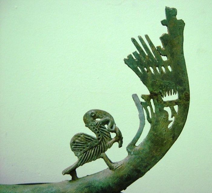 Trên một cán muôi của thầy cúng Đông Sơn có hình chim bồ nông dùng mỏ cắp một con ếch và một chim công lao từ trên trời xuống