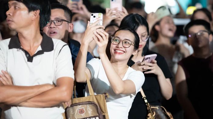 Sự háo hức hiện rõ khi hàng chục ngàn khán giả đồng loạt ghi lại những khoảnh khắc rực rỡ lúc bầu trời sông Hàn bừng sáng.