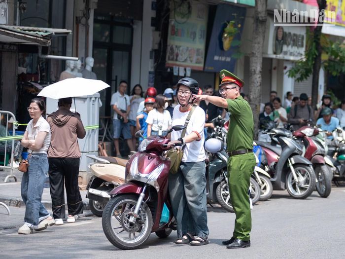 Công an khu vực hướng dẫn người thân của các sĩ tử sắp xếp phương tiện di chuyển vào vị trí.