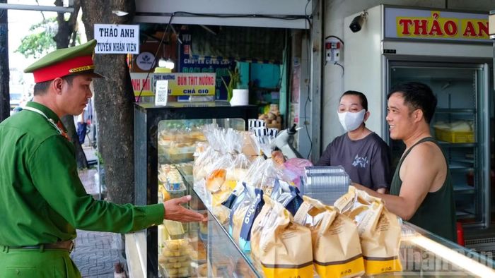 Công an phường Vũng Tàu nhắc nhở người dân thực hiện nghiêm quy định về trật tự lòng, lề đường. (Ảnh: THẾ ANH)