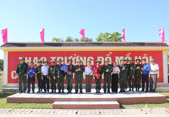 Chỉ huy đơn vị tặng hoa bắn giỏi cho chiến sĩ đạt kết quả giỏi. 