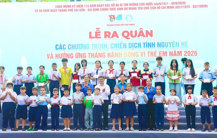  Đồng chí Nguyễn Minh Triết và đồng chí Nguyễn Mạnh Cường trao học bổng cho các em học sinh có hoàn cảnh khó khăn. Ảnh: CẨM TUYẾT 