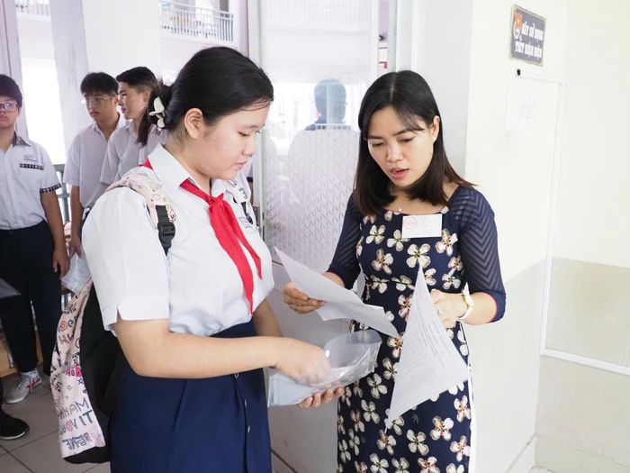  Cán bộ coi thi đọc tên thí sinh vào phòng thi. Ảnh: THU TÂM 