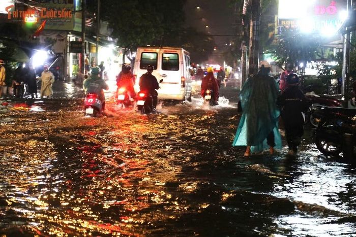 Đến khuya cùng ngày, nước vẫn còn ngập trên đường Bình Trị Đông, nhiều phương tiện phải di chuyển chậm để tránh chết máy.
