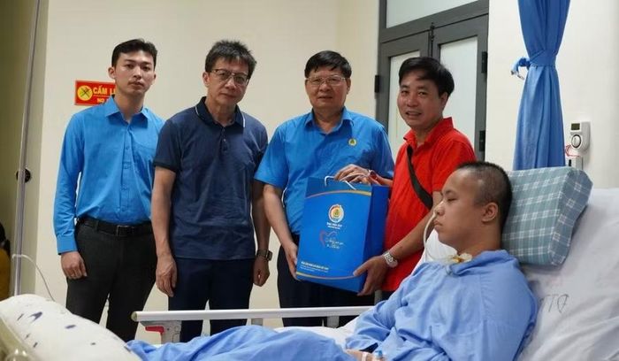 Ông Phan Văn Anh (thứ 2 từ phải sang) và ông Nguyễn Ngọc Ân (thứ 2 từ trái sang) tặng quà gia đình đoàn viên Nguyễn Văn Quân. Ảnh: Quỳnh Chi.