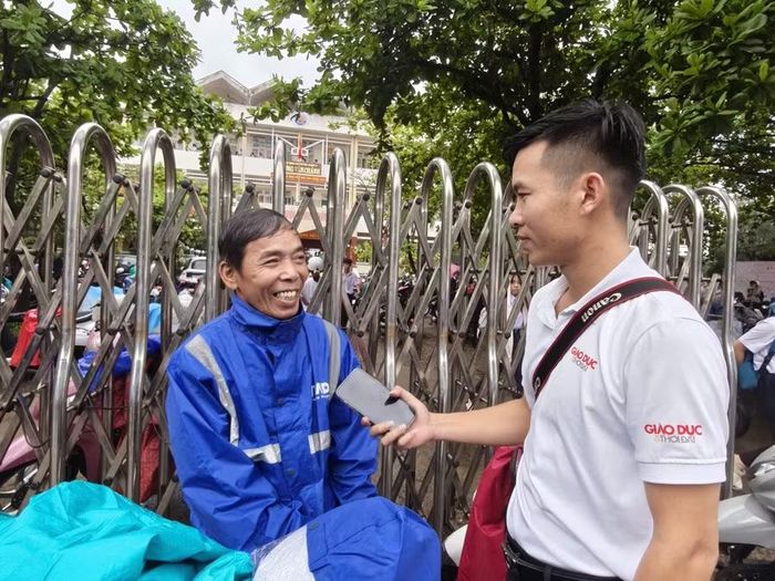 Anh Phan Thanh Bảo đứng chờ con trước cổng trường trong chiều làm thủ tục dự thi. (Ảnh: TT)