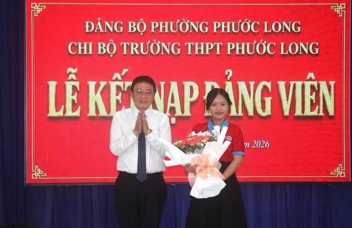Ông Liên Minh Thiện tặng hoa chúc mừng đảng viên trẻ Trần Bảo Nhiên.