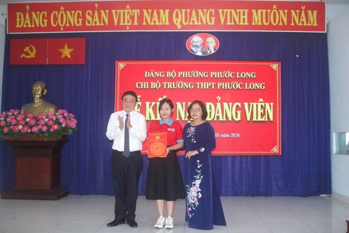 Ông Liên Minh Thiện, Trưởng ban Xây dựng Đảng phường Phước Long và bà Vũ Thị Hồng Châu trao quyết định kết nạp cho đảng viên Trần Bảo Nhiên.