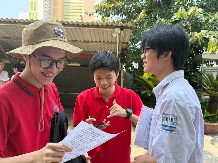 Dù trời nắng nóng, thí sinh vẫn nán lại để trao đổi về đề thi và cách làm bài. (ảnh: Hà Linh)