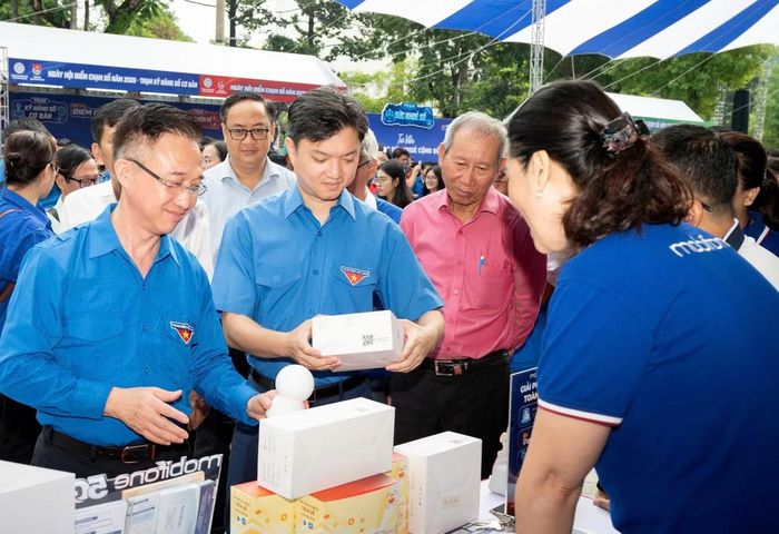 Anh Nguyễn Minh Triết cùng ông Đặng Minh Thông (bìa trái) xem các sản phẩm công nghệ tại lễ ra quân.