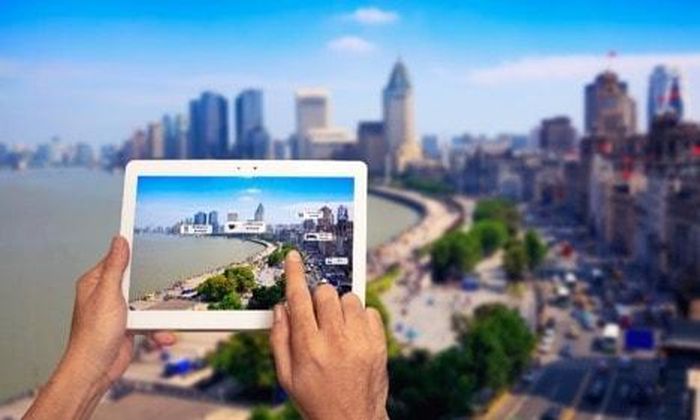 Du khách sử dụng ứng dụng AI để xem thông tin về điểm đến nổi tiếng Bến Thượng Hải, Trung Quốc. Ảnh minh họa: VCG