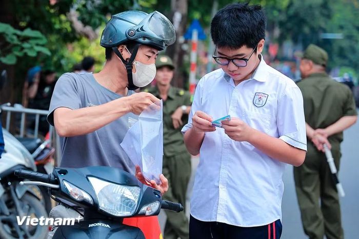 Dù thời tiết Hà Nội có những ngày nắng như đổ lửa hay bất chợt đổ cơn mưa rào, các điểm thi lúc nào cũng đông từ rất sớm. Từ 6h sáng, những chiếc xe máy chở theo ước mơ của cả gia đình đã nối đuôi nhau đổ về cổng trường cùng những lời động viên. (Ảnh: Hoài Nam/Vietnam+)
