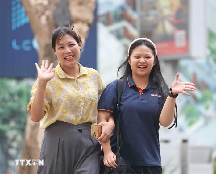 Mẹ đưa con đến trường dự thi môn Ngữ văn. (Ảnh: Thanh Tùng/TTXVN)