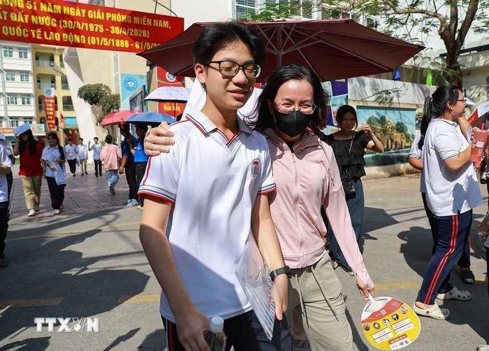 Chia sẻ cảm xúc với con sau khi hoàn thành môn thi Ngoại ngữ tại điểm thi trường THCS Ngô Quyền (phường Bạch Mai). (Ảnh: Khánh Hòa/TTXVN)