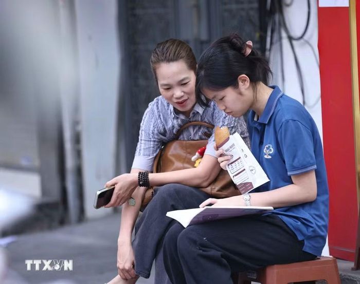 Luôn bên cạnh con trước mỗi môn thi là nguồn động lực tinh thần to lớn giúp các sỹ tử vững bước làm bài, tự tin “vượt vũ môn”. (Ảnh: Thanh Tùng/TTXVN)