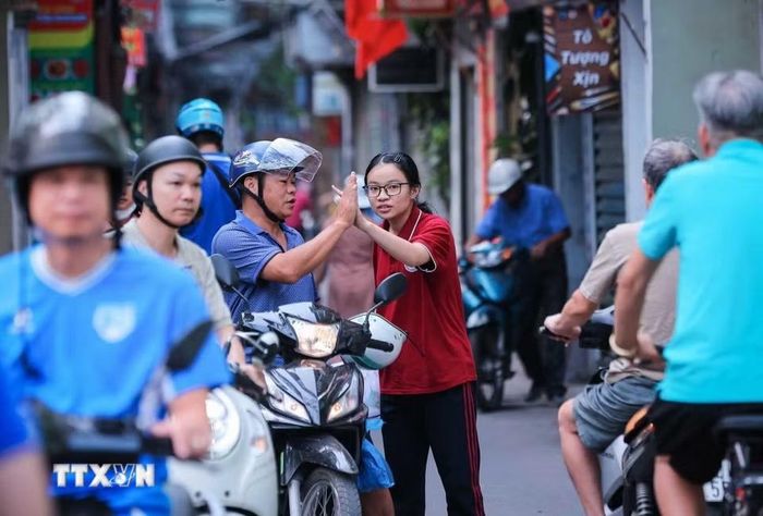 Chúc con hoàn thành tốt môn thi cuối Kỳ thi tuyển sinh lớp 10 công lập tại Hà Nội. (Ảnh: Hoàng Hiếu/TTXVN)