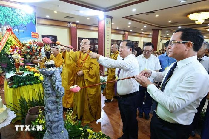 Các đại biểu và Phật tử thực hiện nghi thức tắm Phật. (Ảnh: Minh Đức/TTXVN)