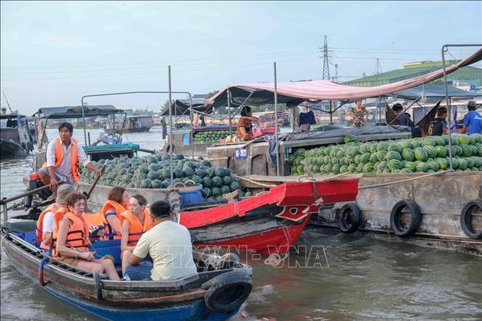 Du khách nước ngoài tham quan chợ nổi Cái Răng (Cần Thơ). Ảnh: Thanh Liêm/TTXVN.