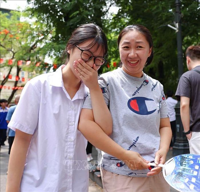Niềm vui mừng của mẹ khi đón con gái hoàn thành tốt môn thi đầu tiên tại điểm thi Trường THPT Trần Nhân Tông. Ảnh: Thanh Tùng/TTXVN