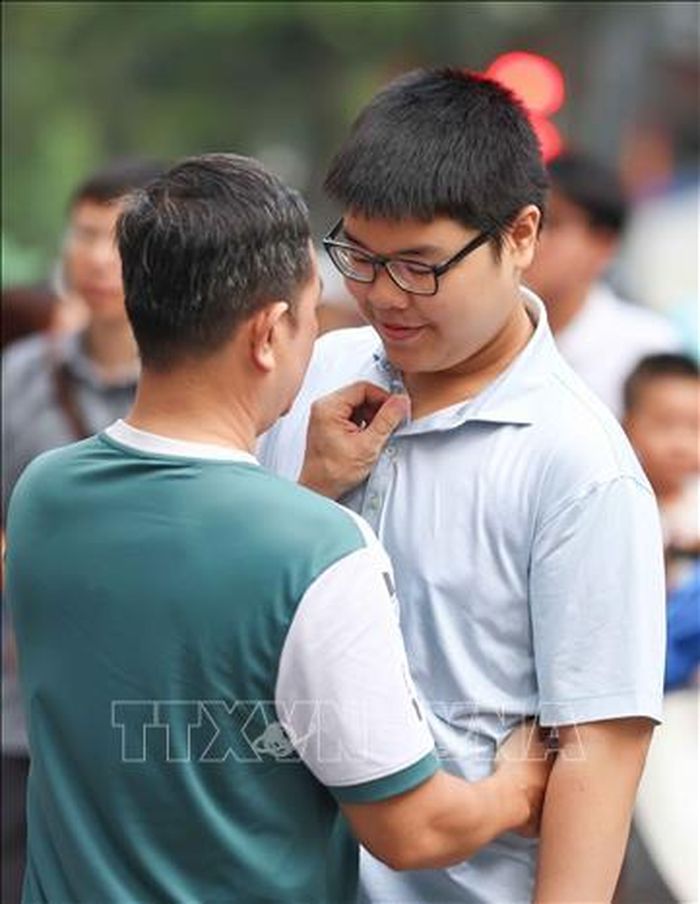 Động viên con trai vững tin trước mỗi môn thi. Ảnh: Thanh Tùng/TTXVN