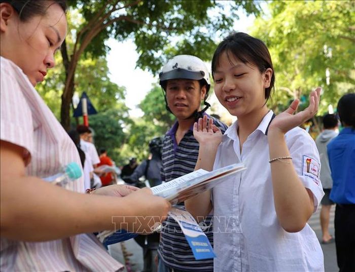 Thí sinh trao đổi về bài làm với người thân sau khi hoàn thành môn thi Ngoại ngữ tại điểm thi Trường THCS Lê Ngọc Hân. Ảnh: Thanh Tùng/TTXVN
