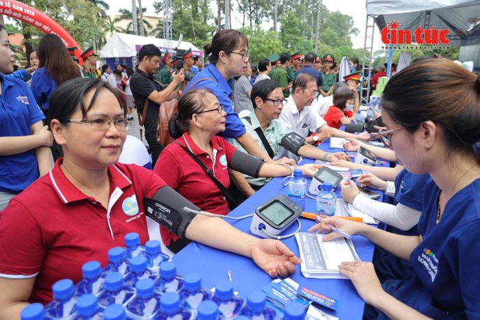 Bà Trần Thị Cúc Tần (áo đỏ, thứ hai từ trái sang) trải nghiệm các trạm công nghệ và chăm sóc sức khỏe tại Ngày hội.