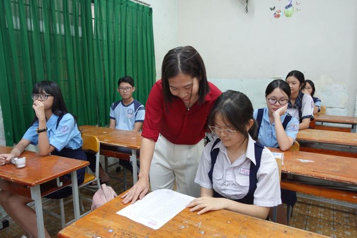 Giám thị tại điểm Trường THCS Lê Quý Đôn hướng dẫn thí sinh kiểm tra lại thông tin cho chính xác.